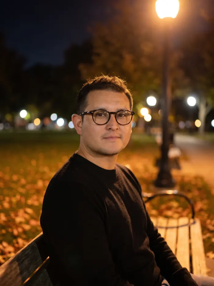 Dennis Alejo seated in a park at night
